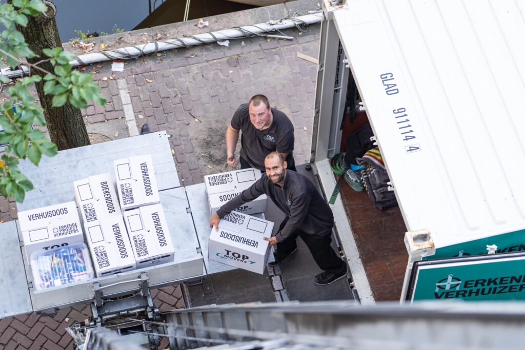 Verhuizers van Holwerda Top Movers laden verhuisdozen in de verhuiswagen tijdens een verhuizing in Zeewolde